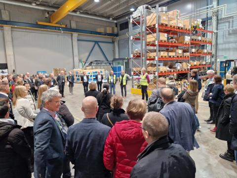 Joukko ihmisiä teollisuushallissa.